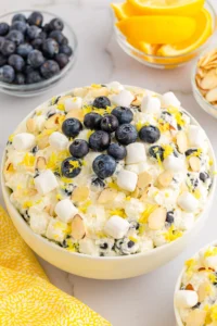 light yellow fluff in bowl with marshmallows and blueberries on top