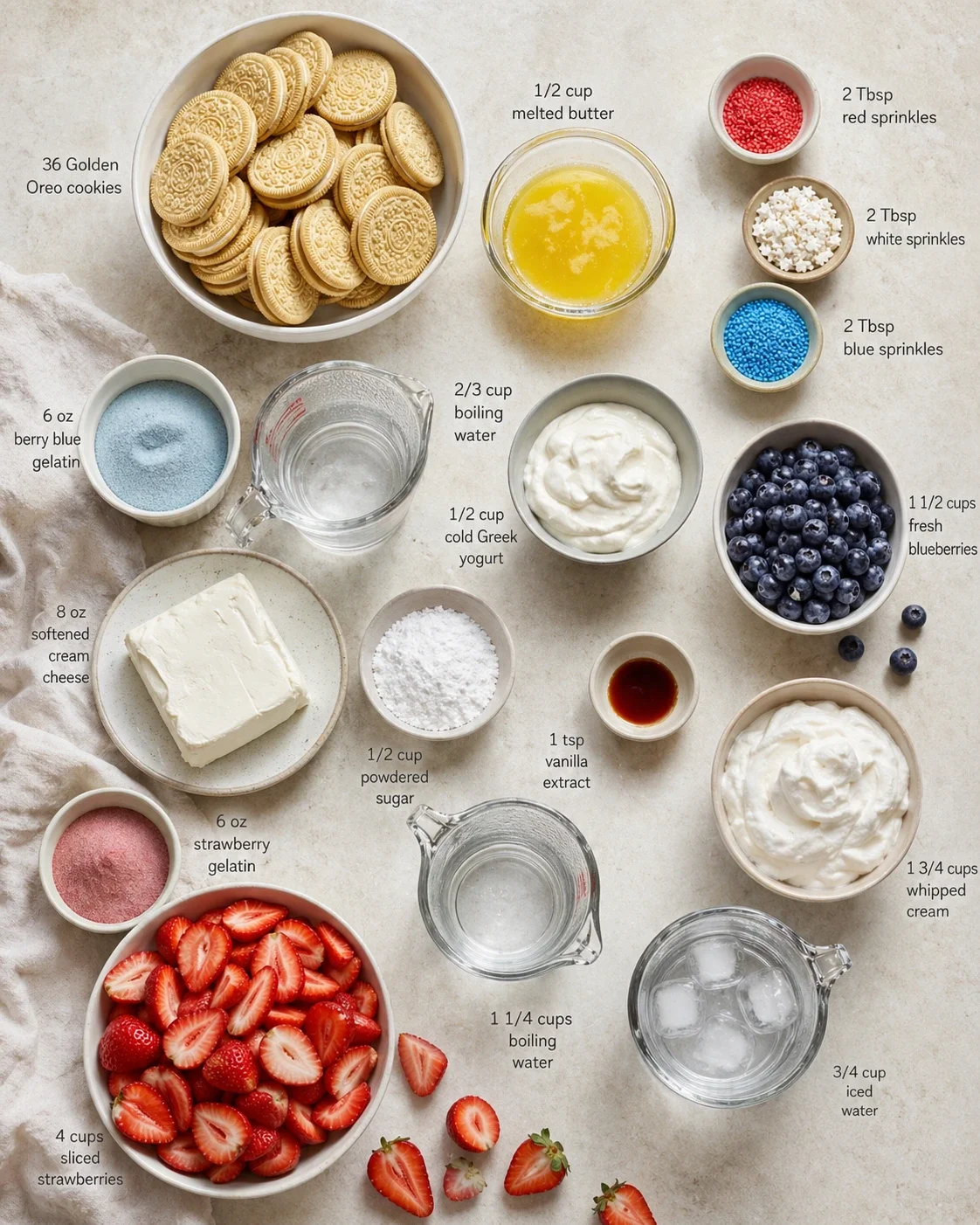 Overhead view of labeled cheesecake ingredients, including Oreos, cream cheese, yogurt, berries, sprinkles, and sugar.