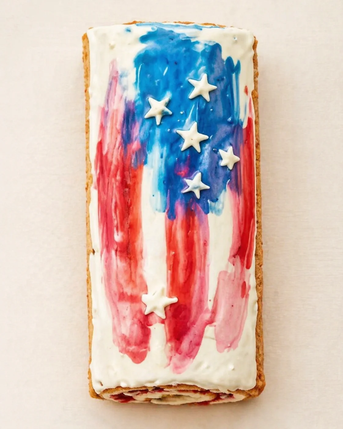 Rectangular cake with white icing, red-blue strokes, and white star decorations.