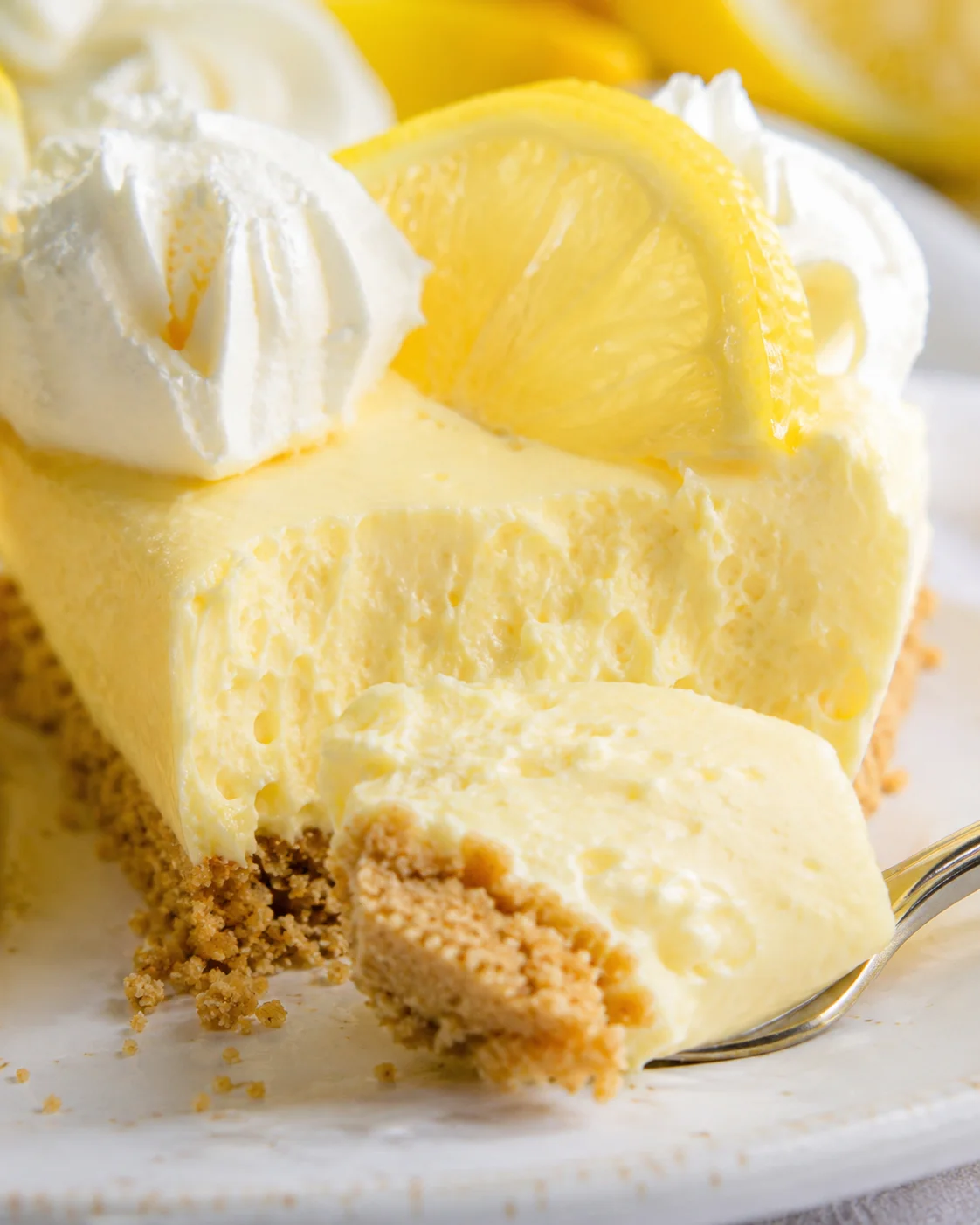 Delicious lemon mascarpone cream pie topped with lemon slices and mint sprig.
