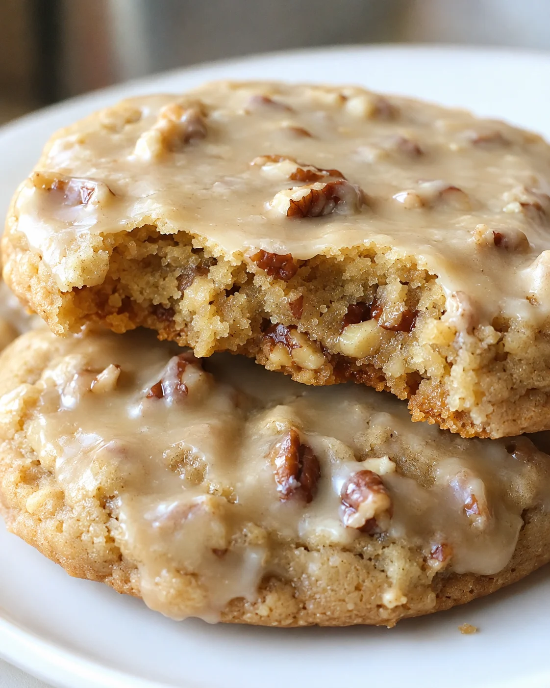 Close-up of soft-centered maple pecan cookies topped with glossy maple glaze.