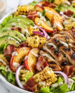 Colorful salad with grilled chicken, peaches, corn, bacon, and creamy dressing