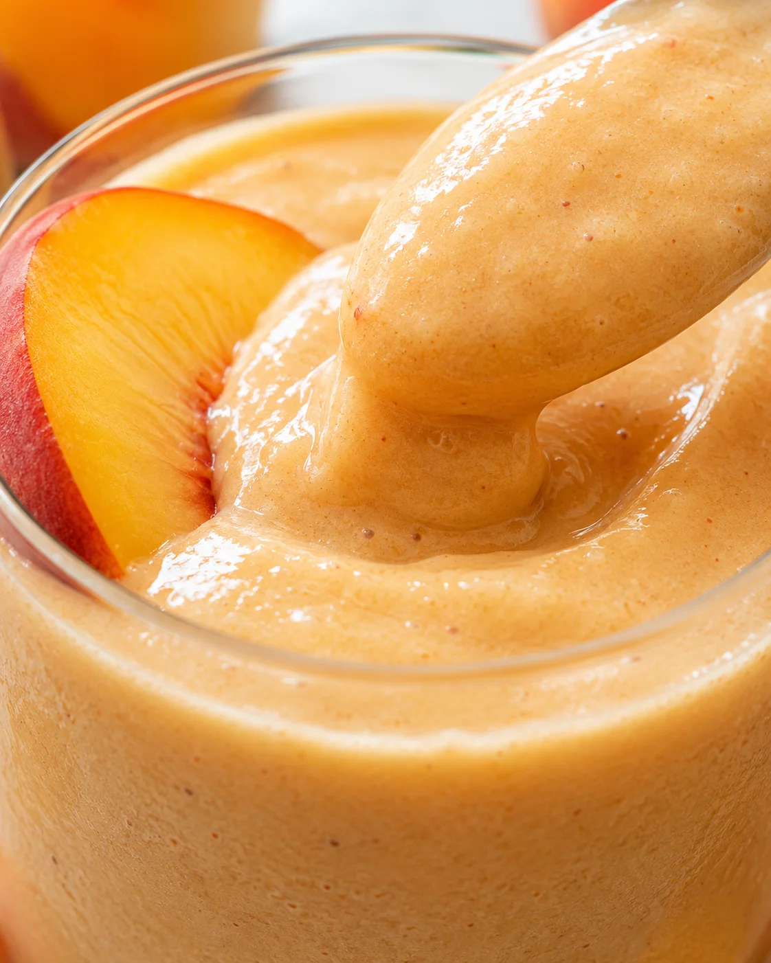 Creamy peach smoothie blended with peaches and pears in a glass.