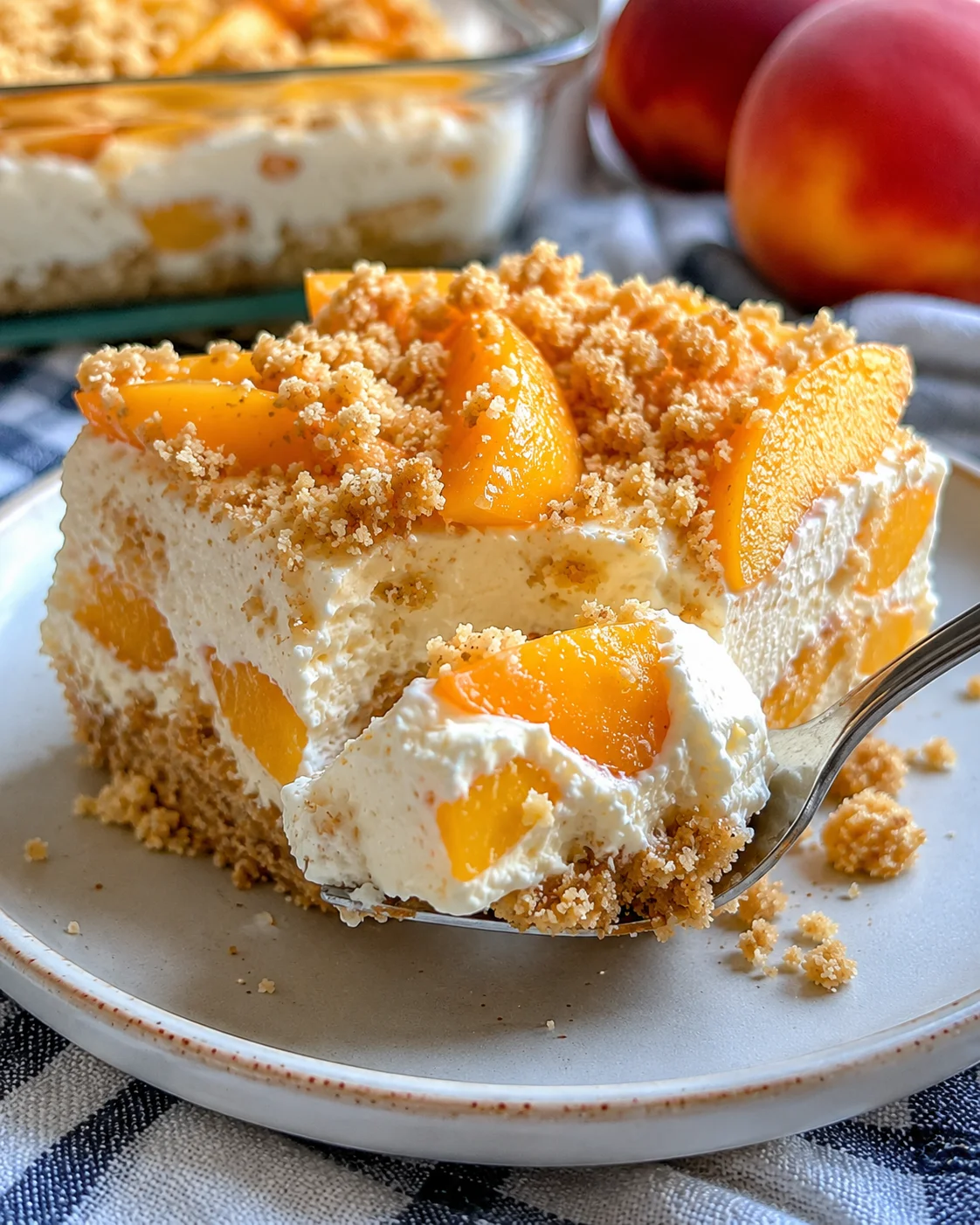 A slice of peaches and cream dessert with fresh peach slices topping.