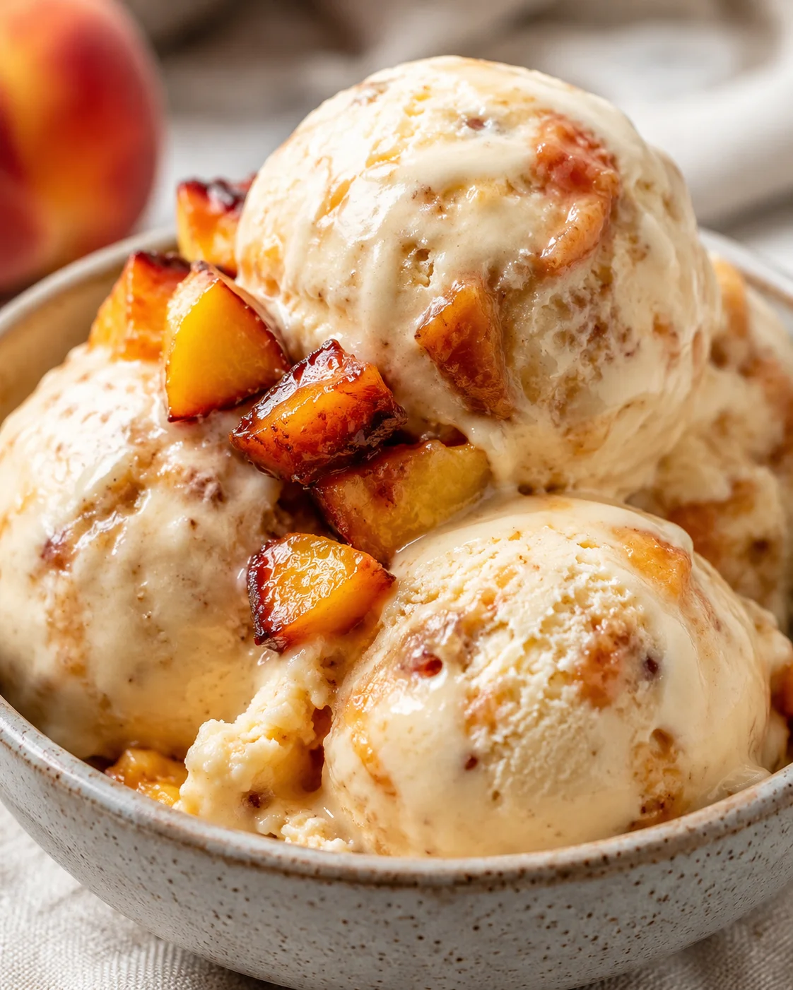 Creamy homemade roasted peach ice cream with caramelized fruit topping