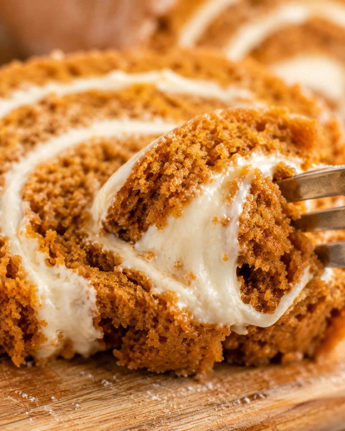 Close-up of a pumpkin roll with creamy filling and crumbly exterior