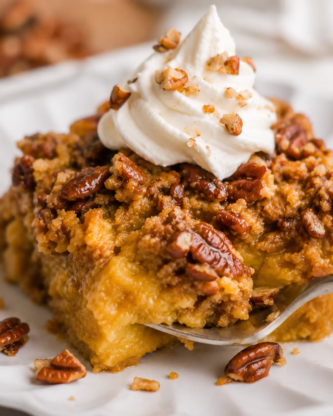 Close-up of a slice of pumpkin crunch cake with whipped cream topping