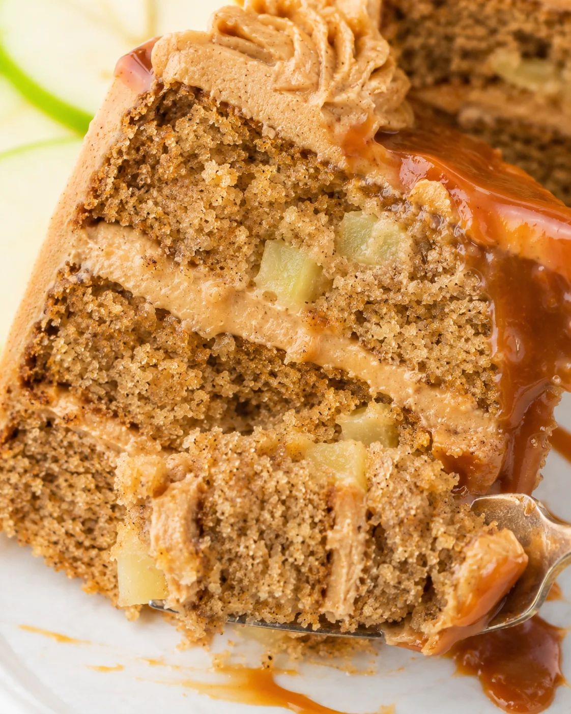Delicious slice of caramel apple spice cake with caramel frosting and apple chunks.