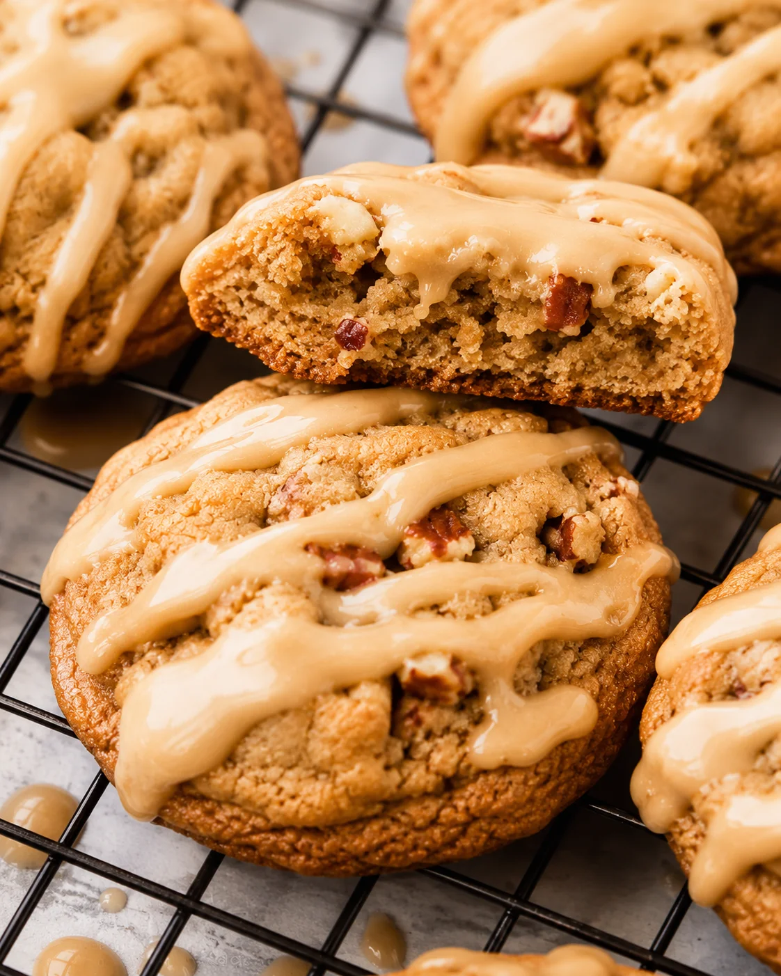 Close-up of maple brown sugar cookies with icing and chewy centers on a cooling rack