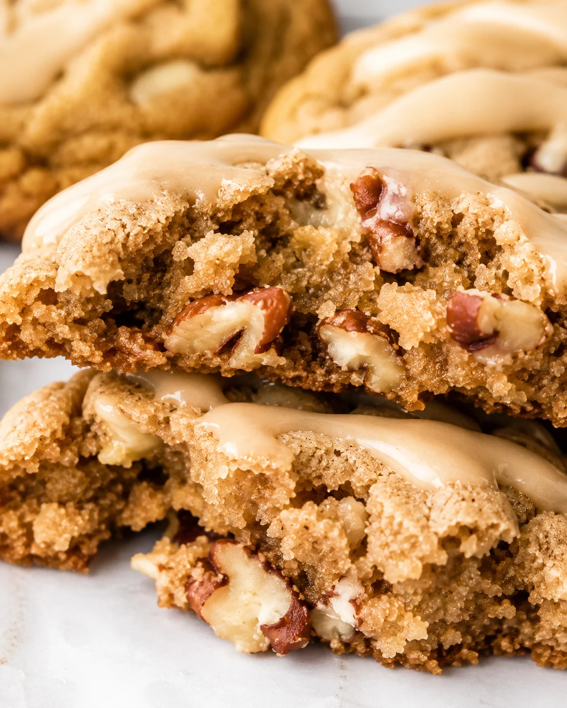 Close-up of cut-open maple brown sugar cookie with nuts and icing