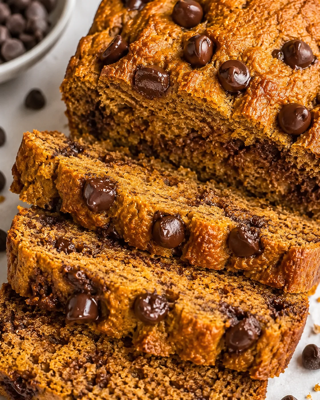 A sliced piece of tasty protein pumpkin bread with chocolate chips on top.