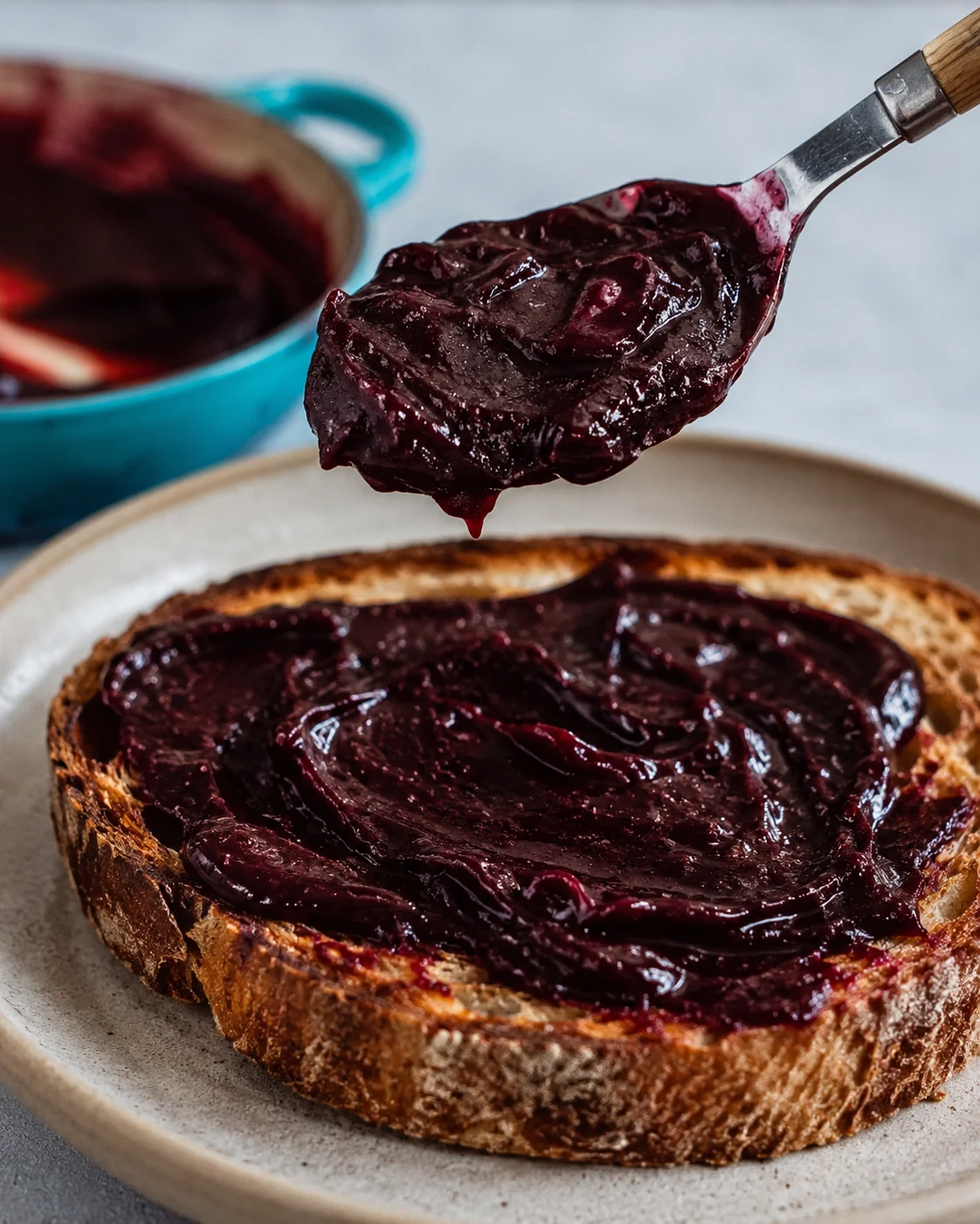 A spoonful of rich vanilla bean plum butter over a toast slice.