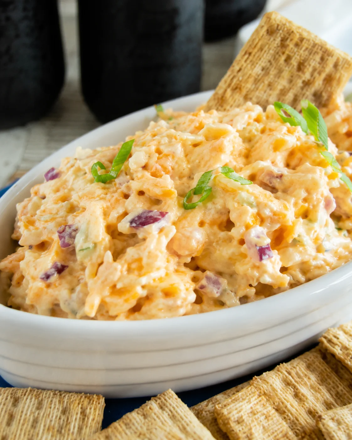Bowl of 5 minute crack dip with crackers and sliced green onion garnish