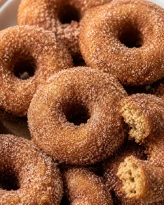 Close-up of golden baked apple cider donuts with sugar coating.