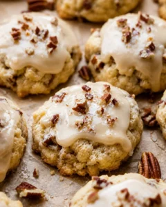 Close-up of maple pecan cookies topped with glaze and chopped pecans.