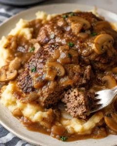 Juicy Salisbury steaks topped with savory mushroom gravy on mashed potatoes