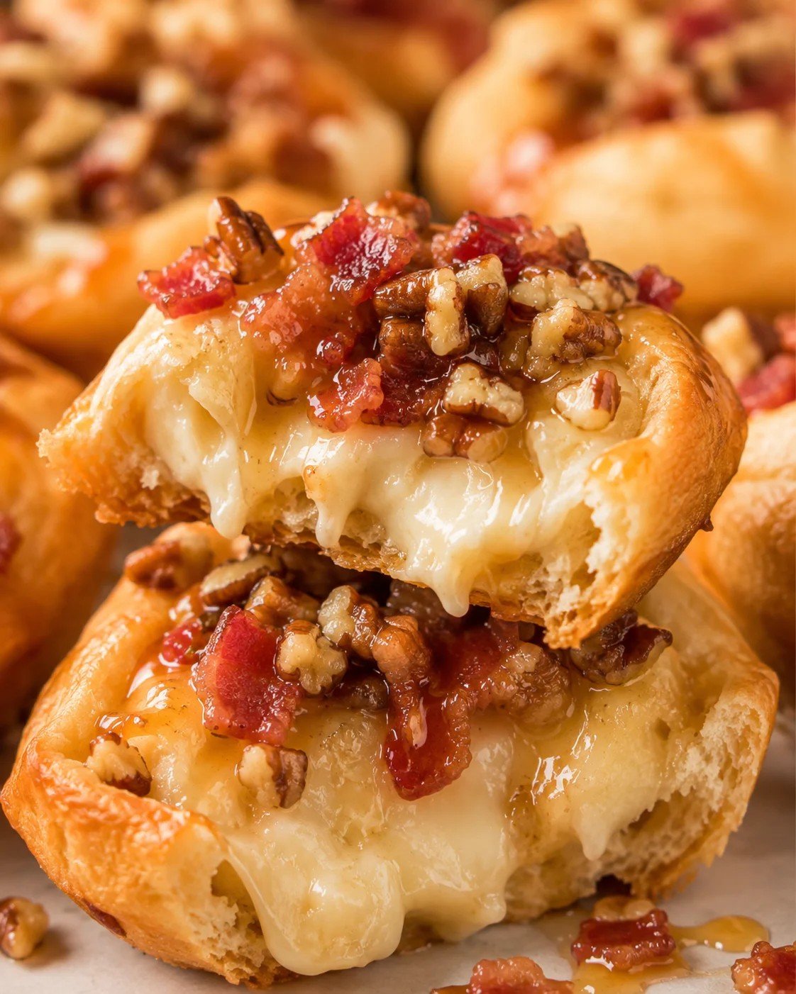 Broken-open Easy Bacon Brie Bite showing the creamy, oozing brie interior with pecans and bacon on top