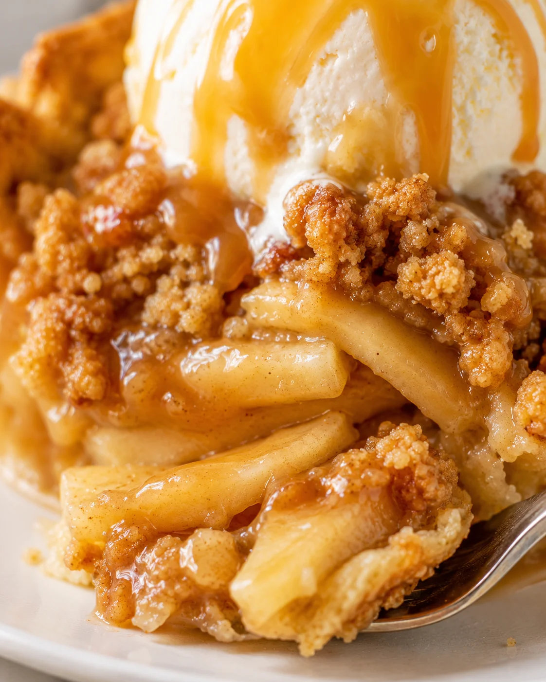 Macro view of the caramel apple pie filling and crunchy crumble topping under melting caramel