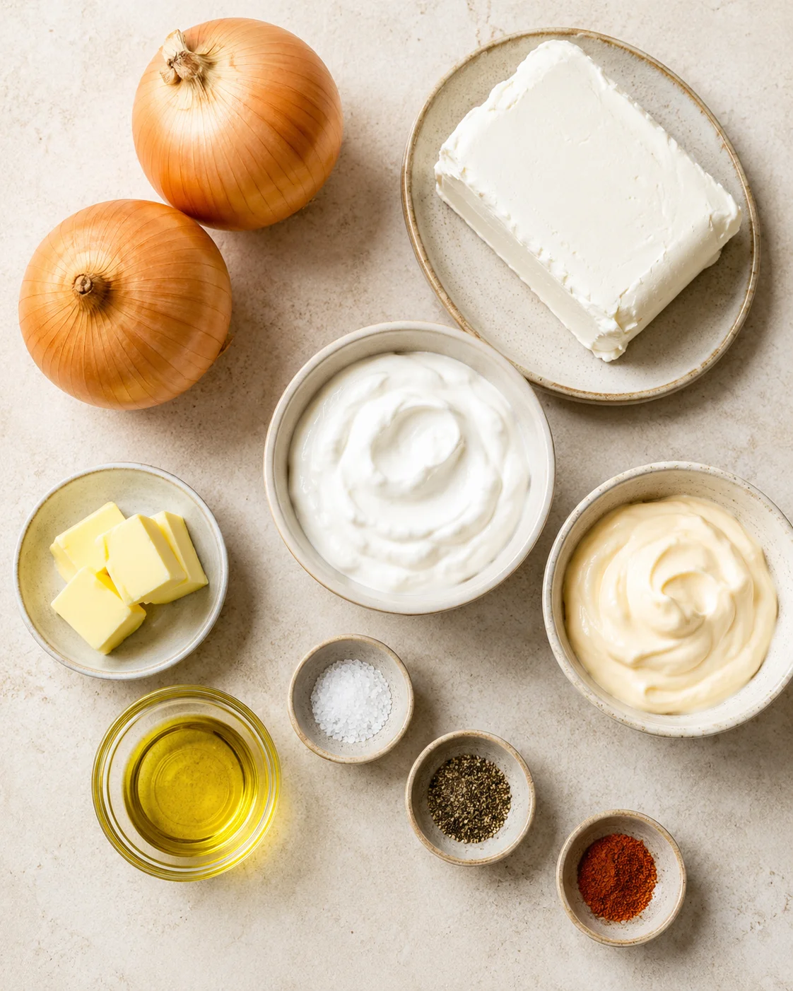 Top-down arrangement of onions, cream cheese, sour cream, mayo, butter, oil and spices for caramelized onion dip