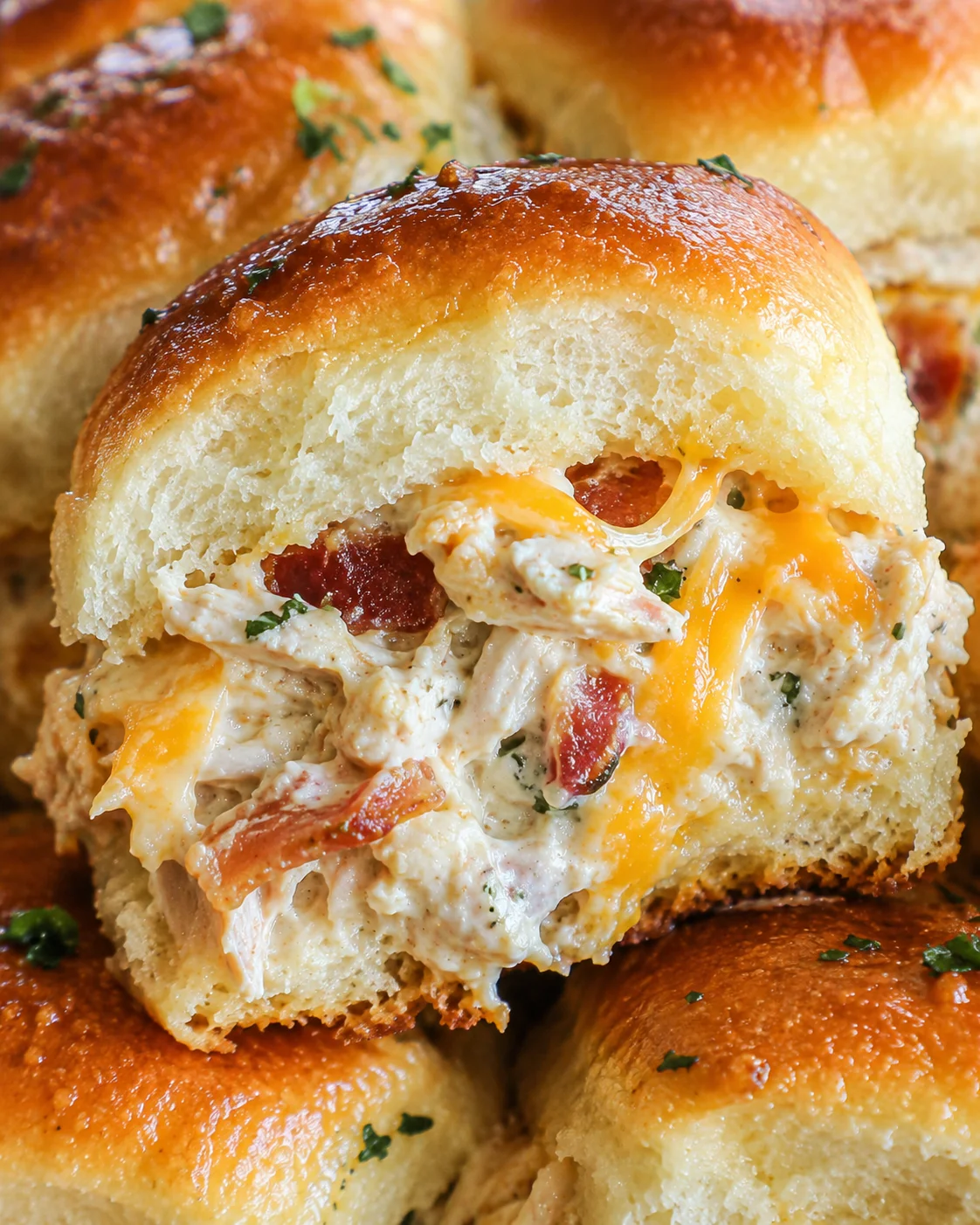 Close-up of a Chicken Bacon Ranch Slider cross-section showing shredded chicken, bacon and melted cheddar