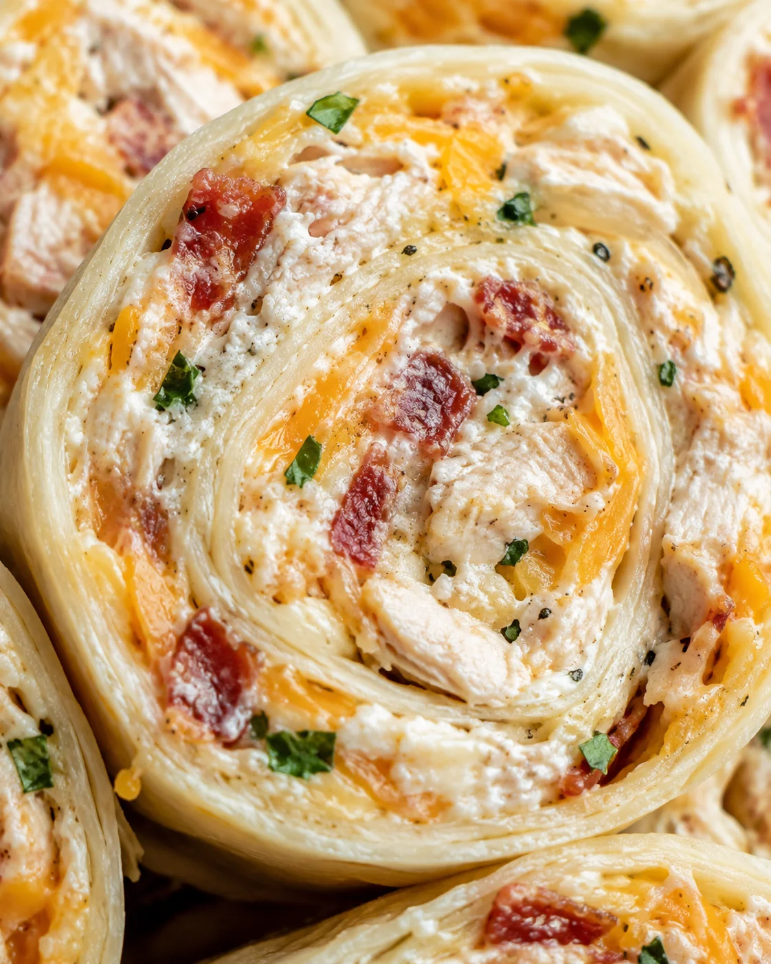 Macro view of pinwheel interior showing chicken, bacon, and cheese