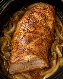 Crock pot pork loin cooked in a slow cooker with caramelized onions