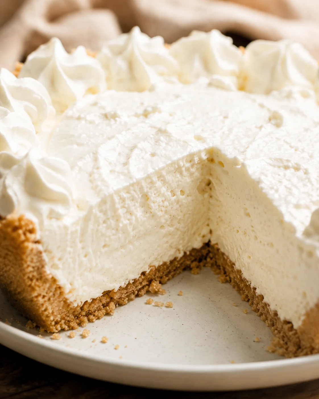 No-bake vanilla cream pie with a slice removed showing the creamy interior and graham crust