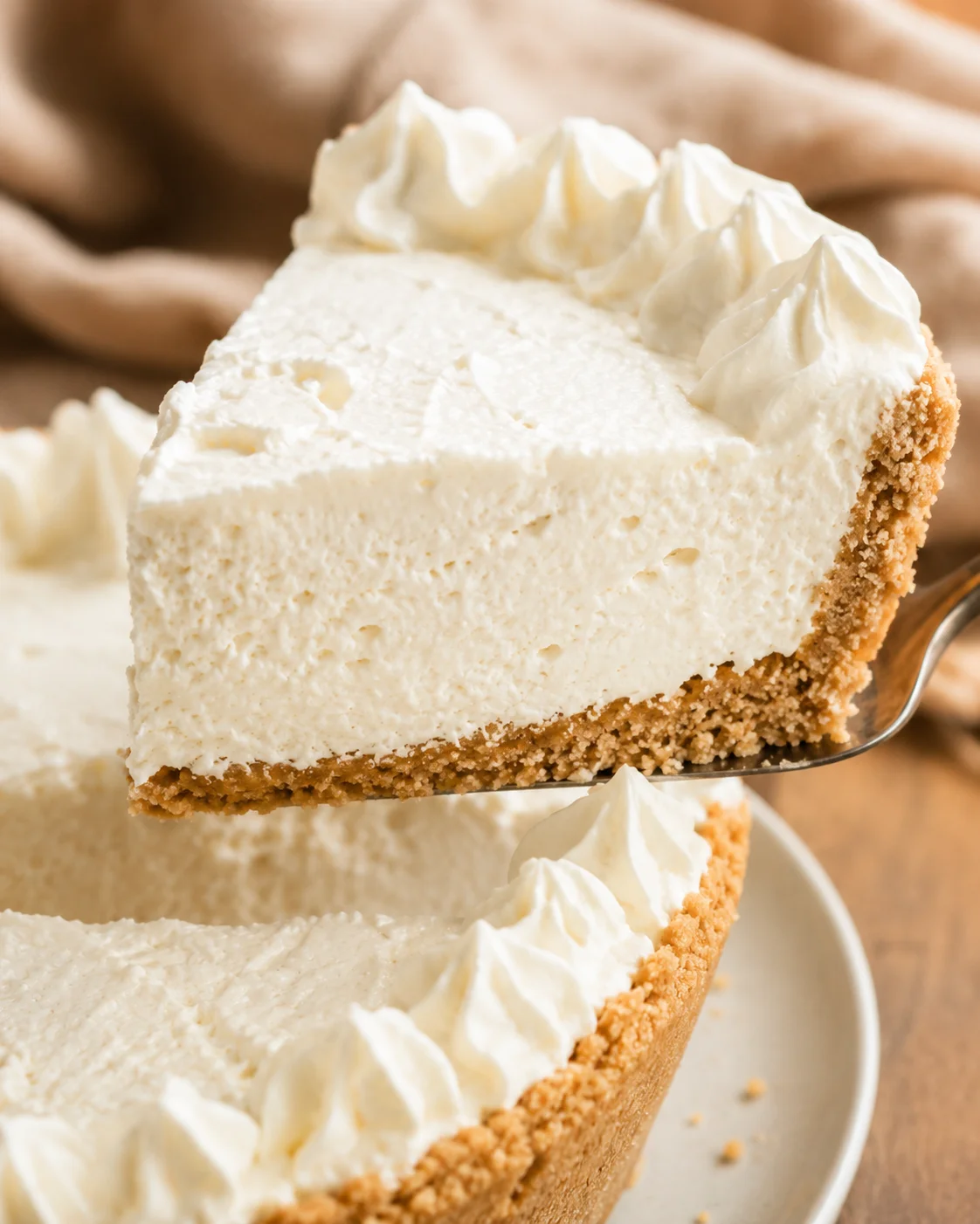 Slice of no-bake vanilla cream pie being lifted from the pie with a spatula