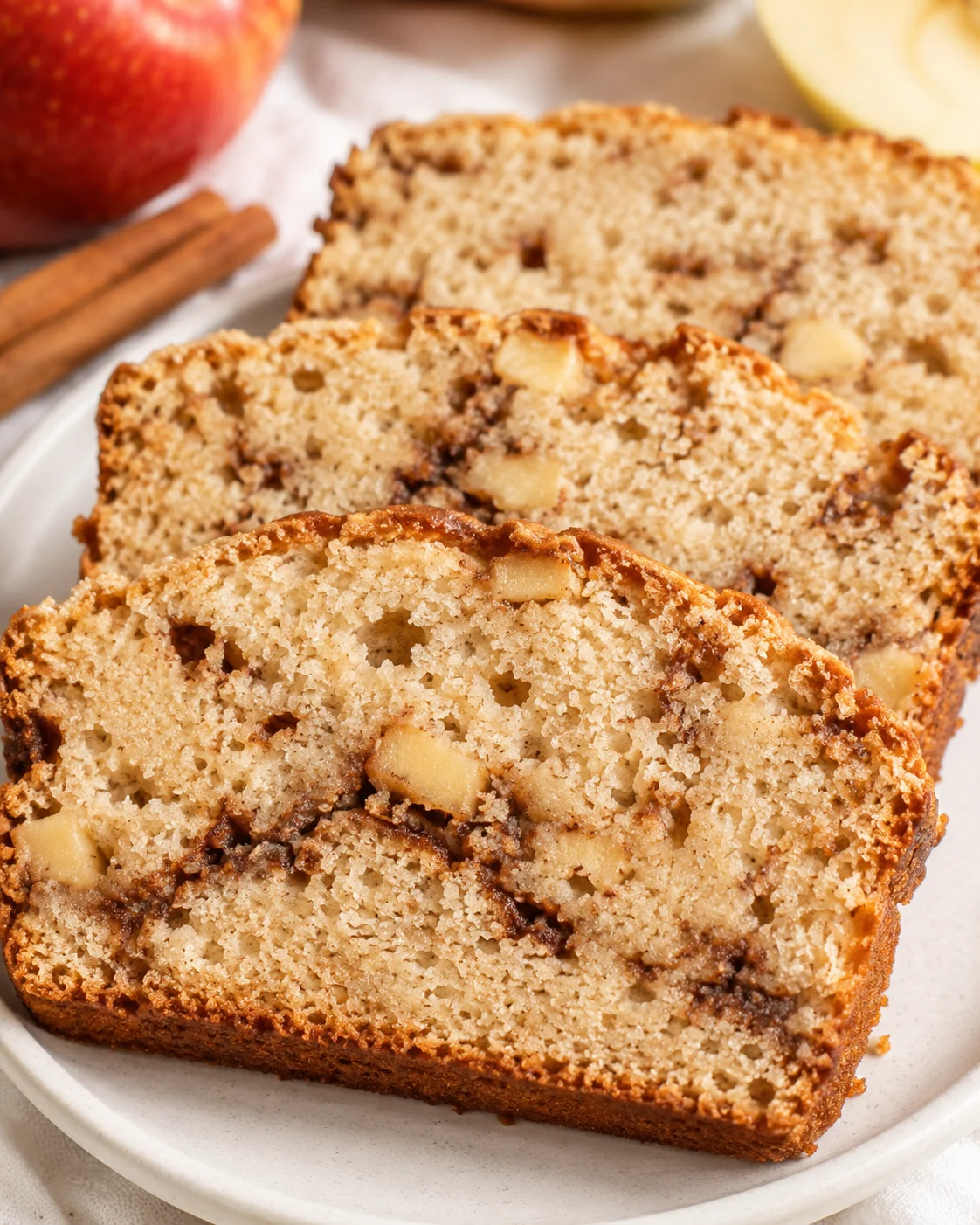 Slices of homemade apple cinnamon bread with apples and cinnamon swirl.