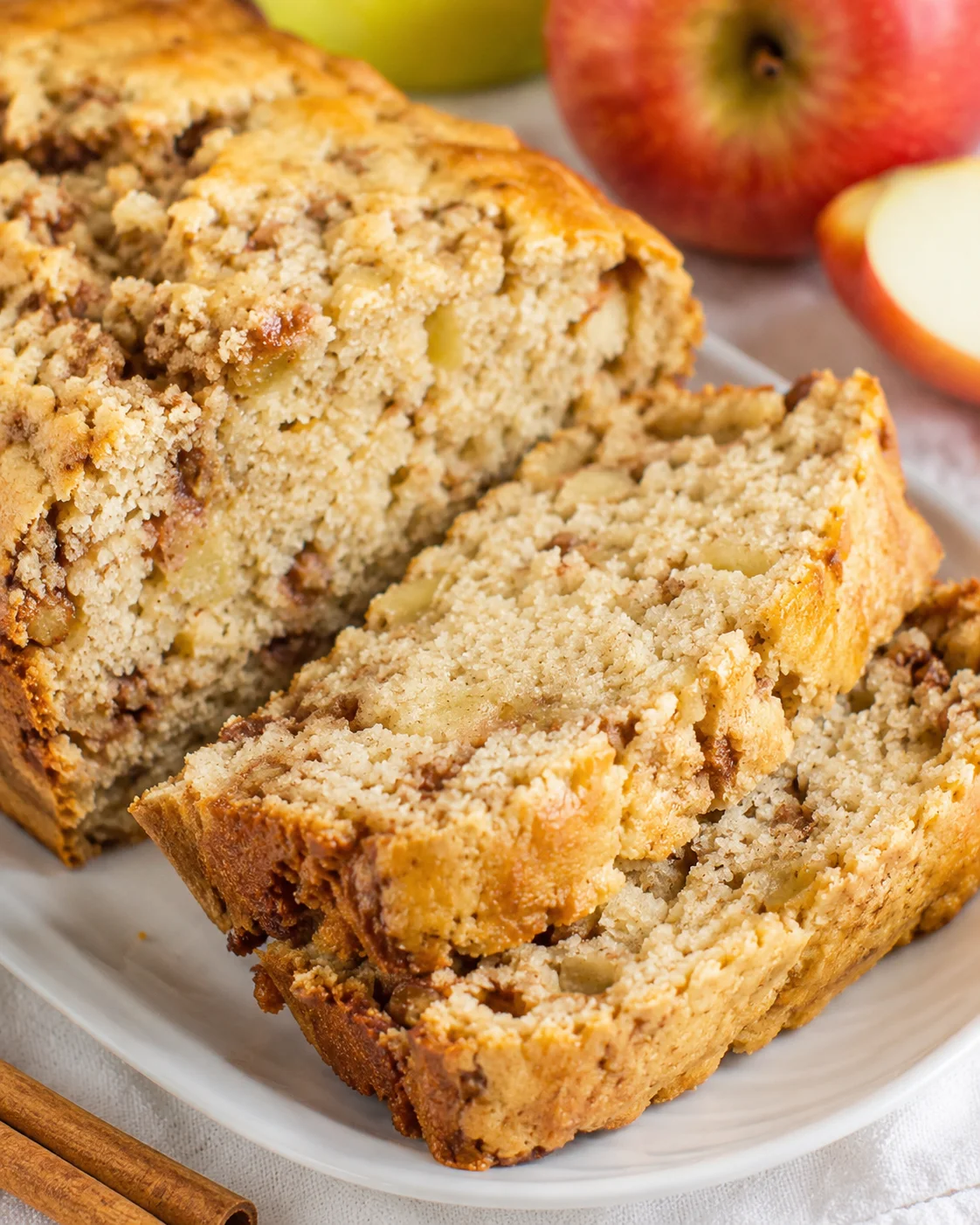 Delicious apple cinnamon bread with fresh apple and crumb topping on a plate