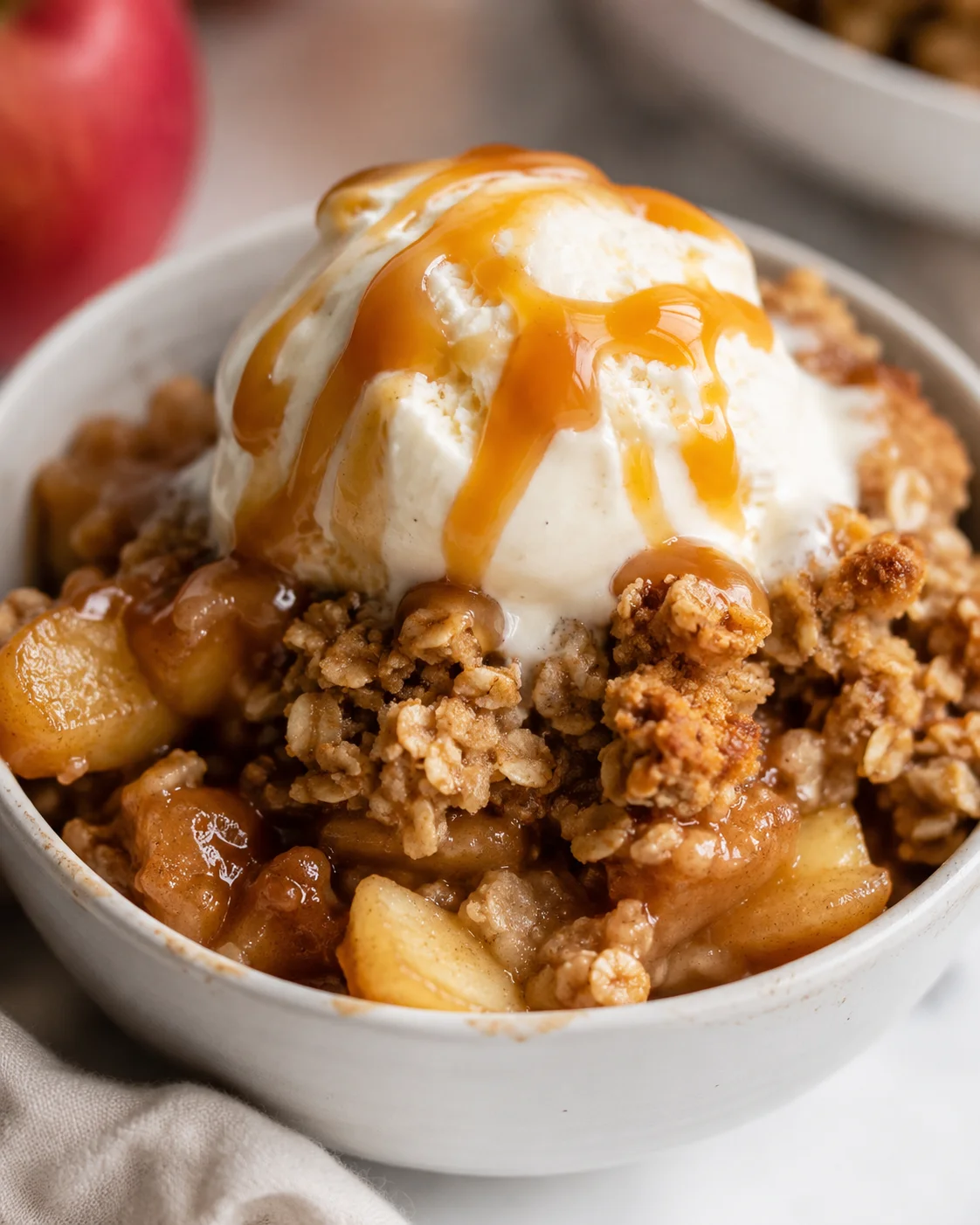 Delicious gluten-free apple crisp topped with ice cream and caramel sauce.