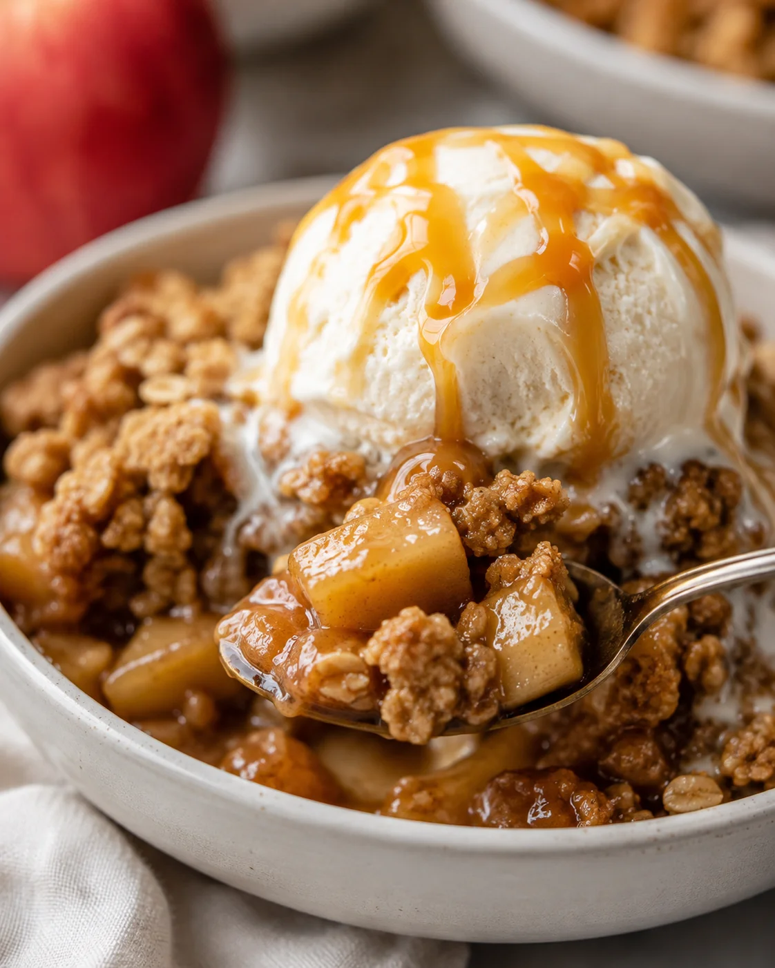Warm gluten-free apple crisp with oat crumble topped with vanilla ice cream.