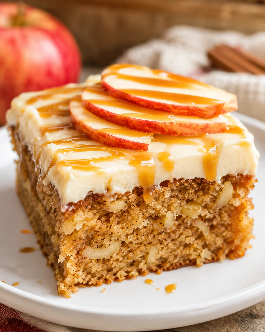 Delicious caramel apple cake topped with sliced apples and caramel drizzle.