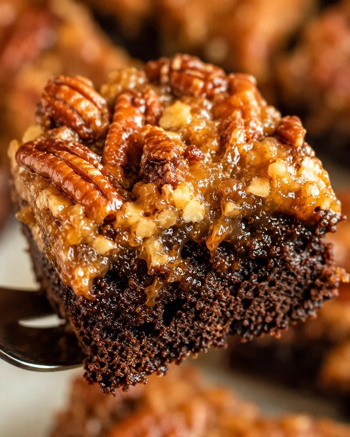 Close-up of a rich, fudgy brownie topped with gooey pecan pie layer