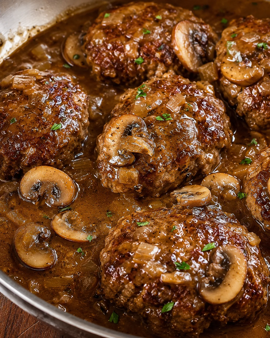 Juicy Salisbury steak patties served with savory mushroom gravy and sliced mushrooms.