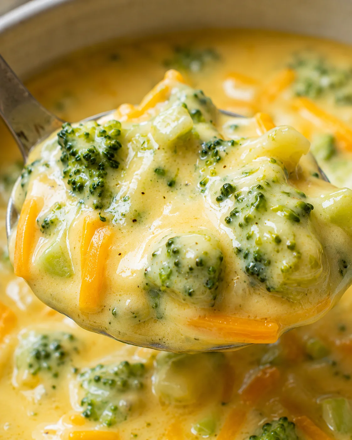 Creamy broccoli and cheddar cheese soup served in a bowl.