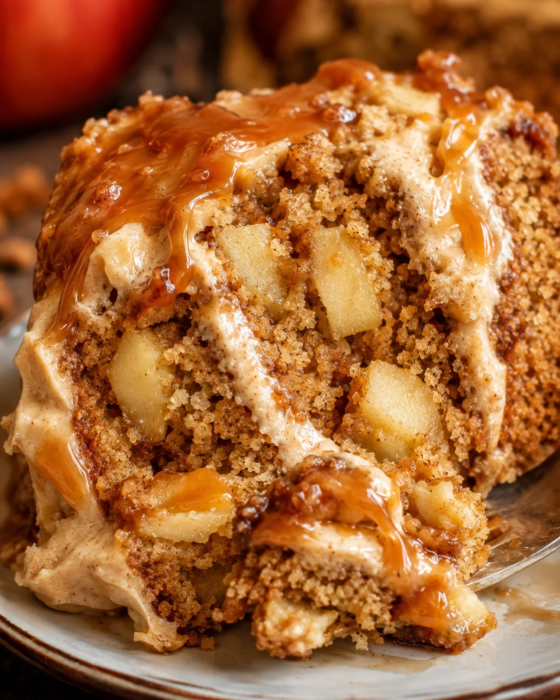 Close-up of a sliced caramel apple cake with caramel drizzle and apple chunks