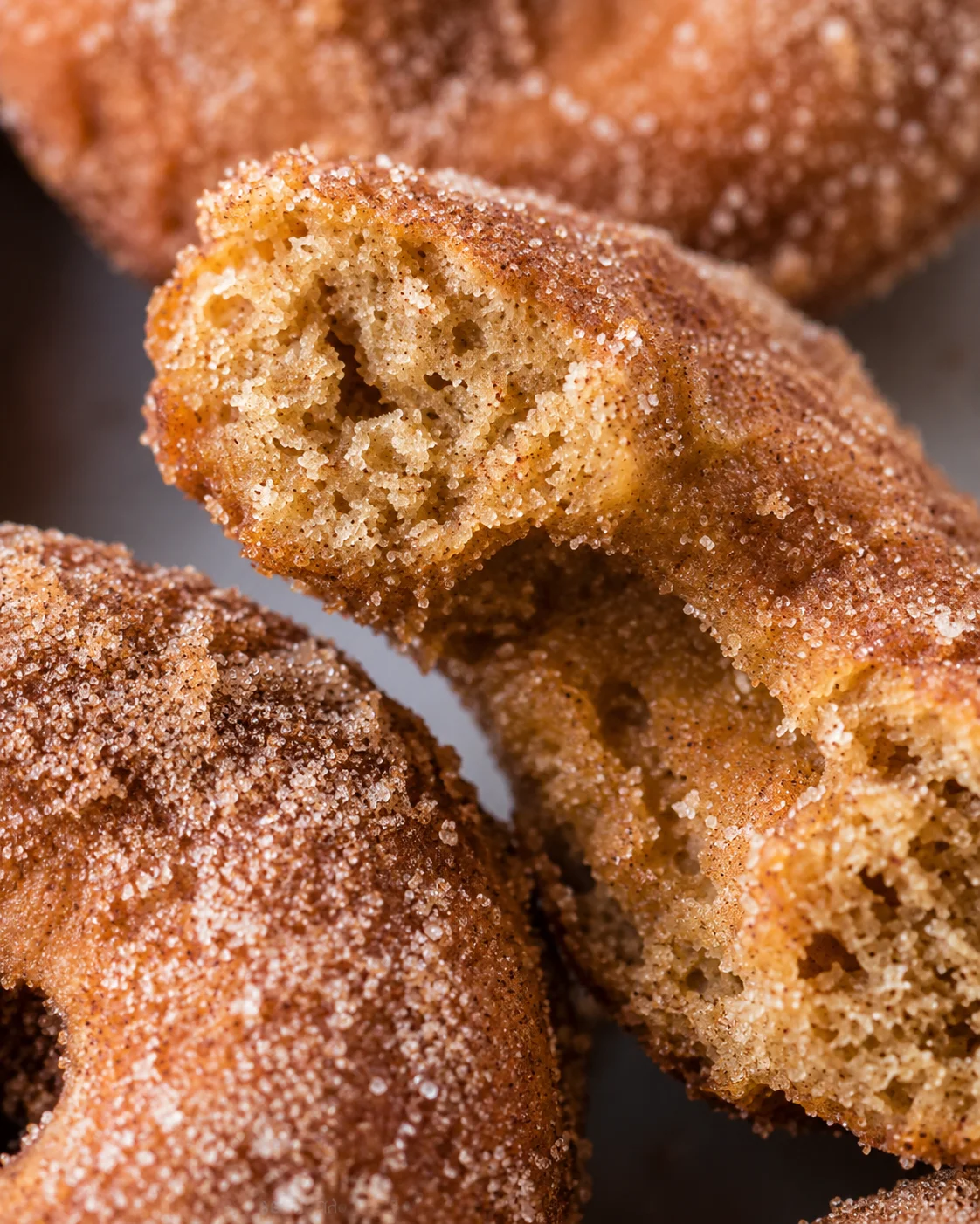 Close-up of freshly baked apple cider donuts with cinnamon sugar coating.