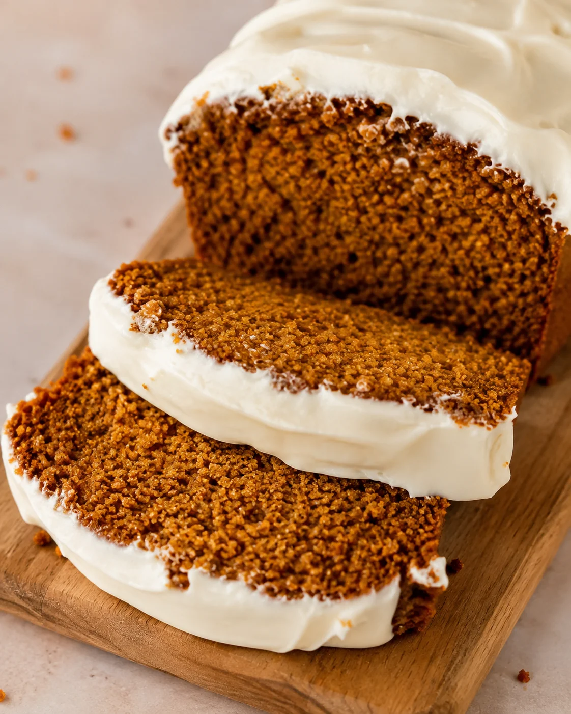 Moist pumpkin bread topped with creamy, tangy cream cheese frosting, perfect for fall.