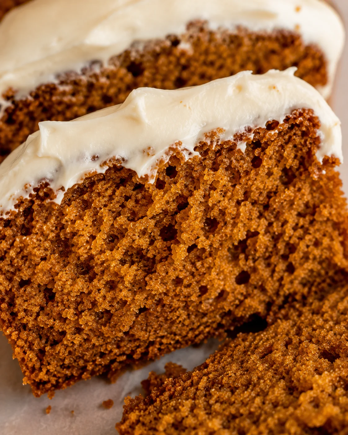 Close-up of moist pumpkin bread topped with creamy cream cheese frosting.