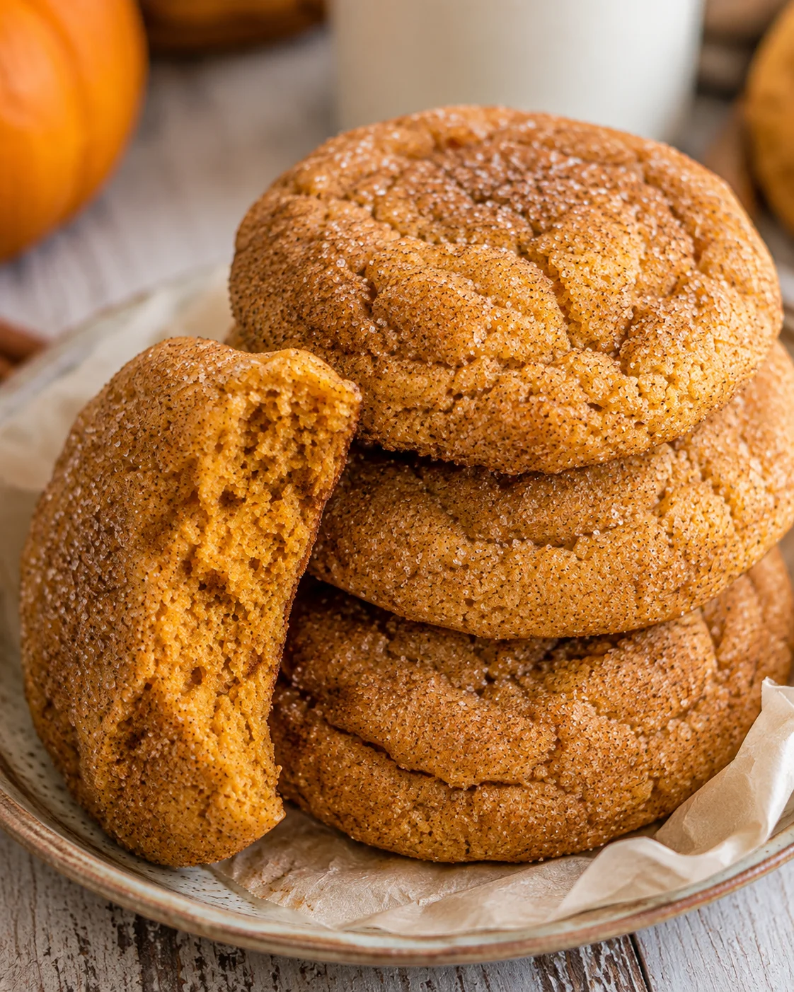 Stack of soft, chewy pumpkin snickerdoodle cookies with cinnamon sugar coating.