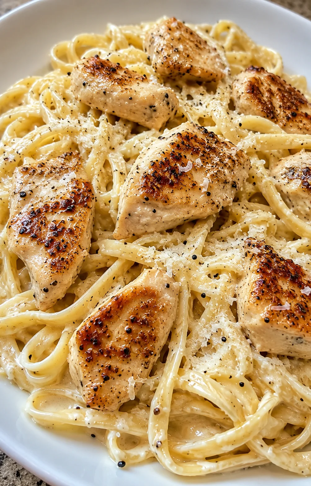 creamy pasta with seared chicken pieces in parmesan cream sauce